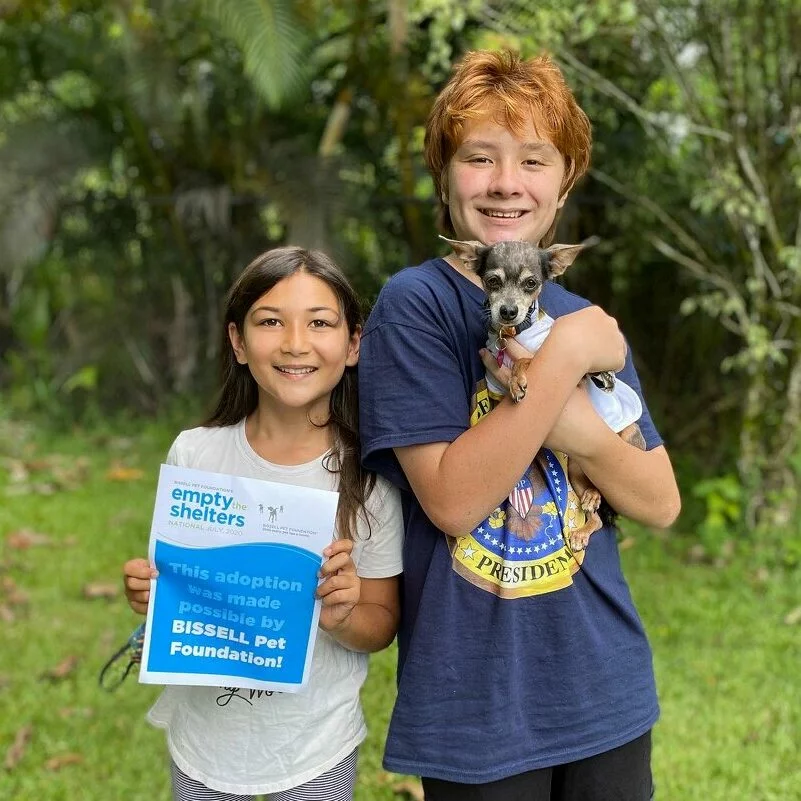 Boy and girl with a small dog adopted at Empty the Shelters